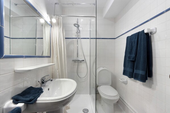 Une salle de bain équipée d’une douche, de toilettes, d’un lavabo et d’un porte-serviettes.