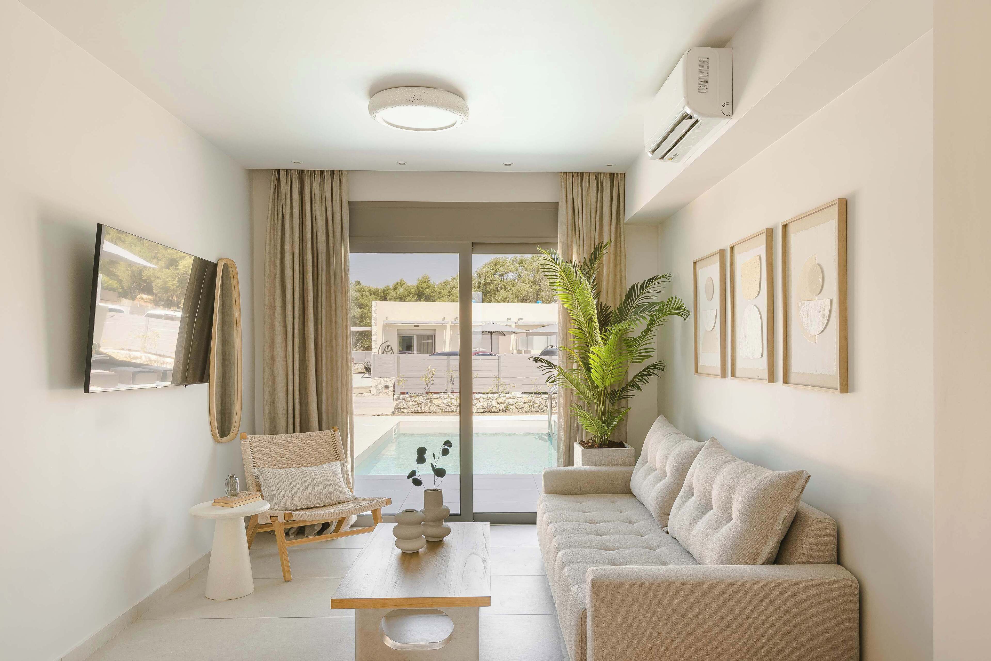 A modern living room with a sofa, a chair, a small table, and a potted plant.