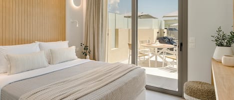 A modern bedroom with a large bed, a sliding glass door to a patio, and a ceiling fan.