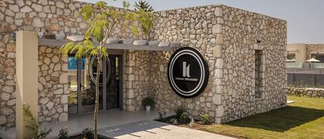 A stone building with a circular logo reading "IONIAN TREASURE" on the facade.