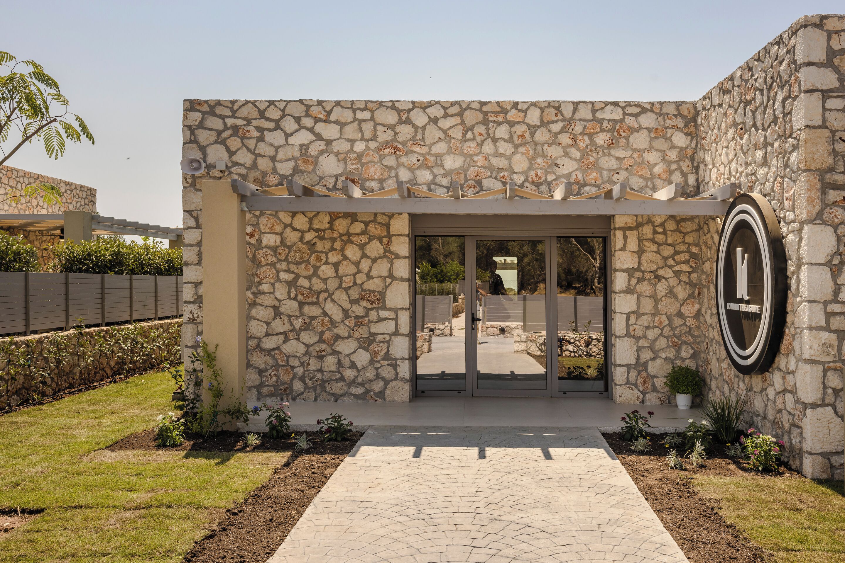 A stone building entrance with a pathway leading to a gated door.
