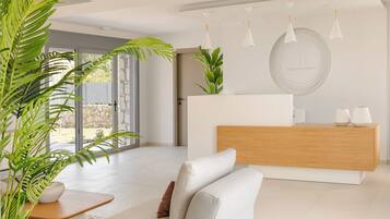 A modern reception area with a wooden reception desk, a white sofa, and potted plants.