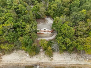 A house surrounded by dense forest, with a dirt path leading to it. - Beavershore | Easy Access to Beaver Lake. Sleeps12 (Eureka Springs)