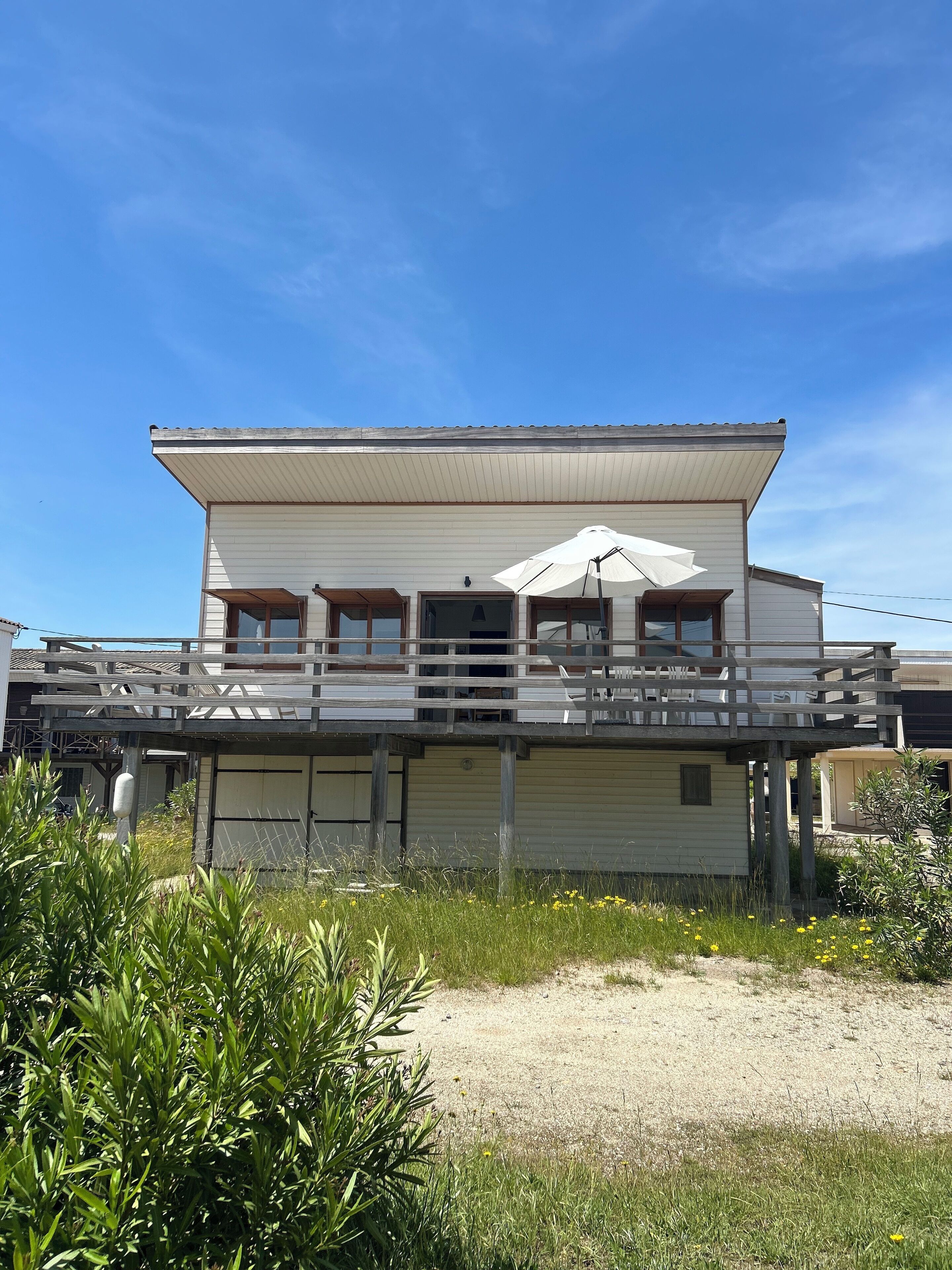 A two-story house with a balcony and a covered patio area.