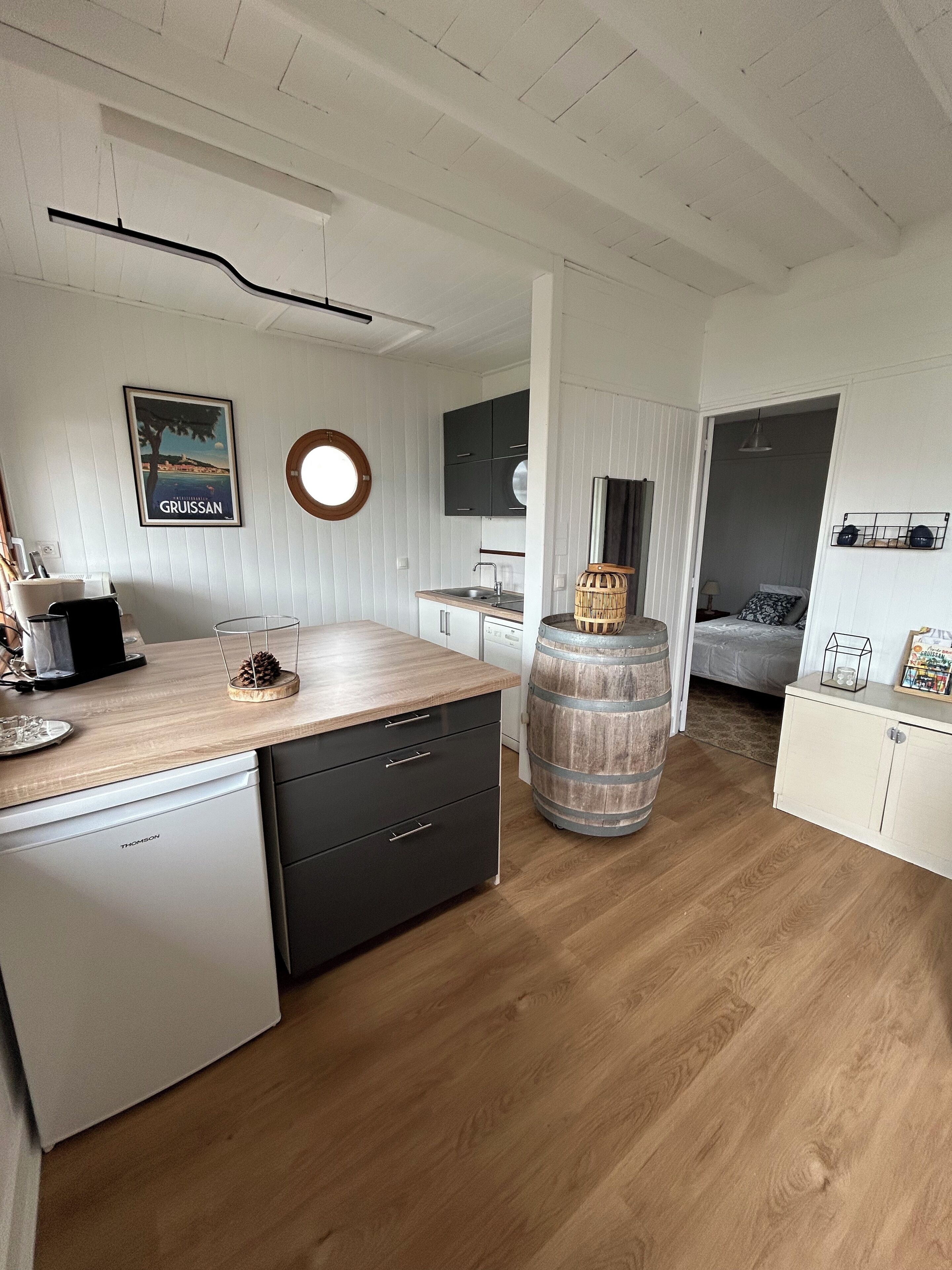 Une cuisine compacte dotée d’un plan de travail en bois, d’un lave-vaisselle et d’un grand tonneau.