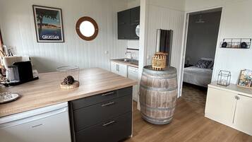 Une cuisine compacte dotée d’un plan de travail en bois, d’un lave-vaisselle et d’un grand tonneau.