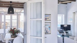 A modern living room with a television, seating, and artwork on the wall. - Aegean Scent  (Mykonos)