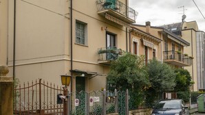 A multi-story building with balconies, a gated entrance, and a parked car. - Attico Vintage Colette by Rentbeat (Verona)