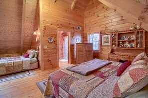 A log cabin bedroom with two beds, a dresser, and a cabinet with decorative items. - Secluded Log Cabin Rental with a Hot Tub in the Hocking Hills, Ohio (Logan)