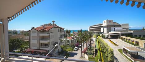 Un balcon donnant sur un quartier résidentiel, avec vue sur des immeubles et une rue.
