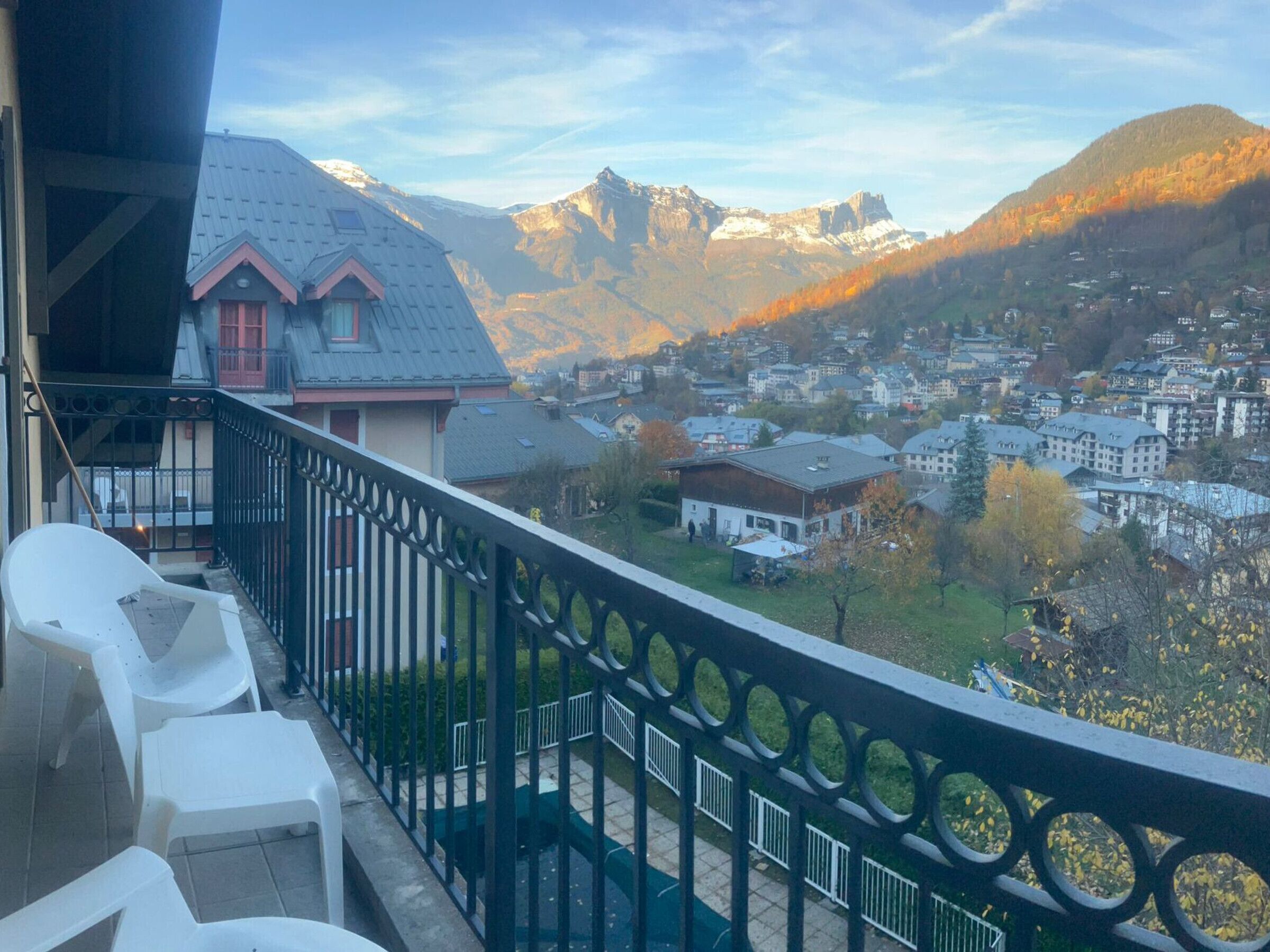 A balcony with a view of a town and mountains.