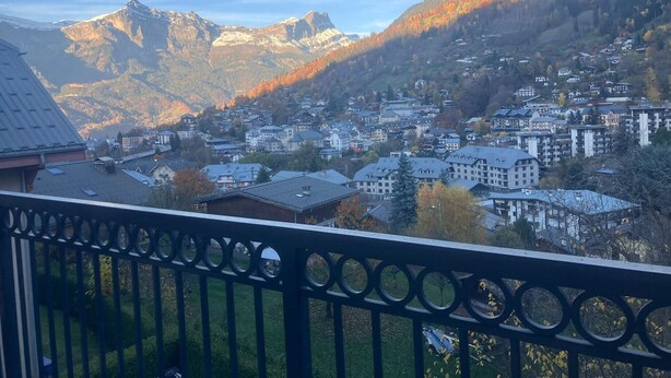 Eine Stadt eingebettet in ein Tal, mit Bergen im Hintergrund.