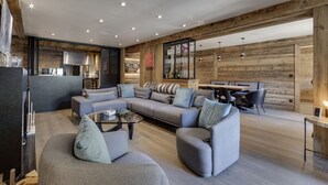 En moderne stue med en hjørnesofa, et sofabord og et spiseområde med stole.