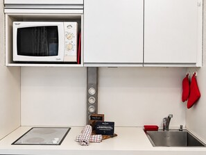 A kitchen with a microwave, a sink, and red oven mitts hanging on the wall. - Bright studio at slope's foot, 3 pers - Méribel (Méribel)