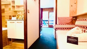 Et hotelværelse med en seng, et lille skrivebord og udsigt ud.