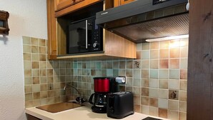 A kitchen with a microwave, coffee maker, and dishwasher. - 2-room apartment with pool access, near slopes, max 4 guests (Pralognan-la-Vanoise)