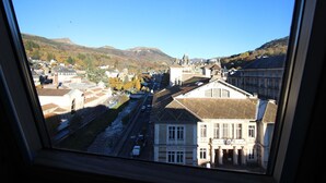 Vista desde una ventana que da a un pueblo con edificios históricos, una iglesia y un río.
