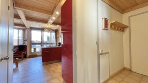 Una habitación con techo de madera, una pared de acento roja y suelo de baldosas.
