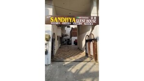 Entrada a una casa de huéspedes con un cartel que indica servicios como salón de banquetes, restaurante, habitaciones con aire acondicionado y estacionamiento.