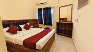 Un dormitorio con una cama de madera, una mesita de noche, un aparador y un espejo.