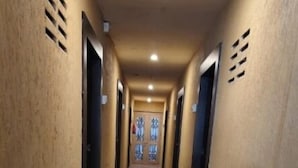 Un pasillo largo y estrecho con un suelo brillante y reflectante, y puertas a ambos lados.