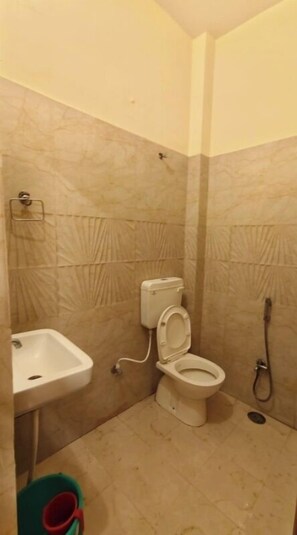 Un baño pequeño con inodoro, lavamanos y ducha.