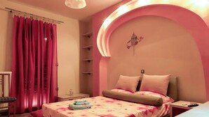 A bedroom with a bed, a nightstand, a chair, and a shelf unit. - The Sunset Haven Kastoria Modern Lake Elegance (Kastoria)