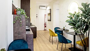 A modern interior with a wooden floor, a black table, and blue and yellow chairs. - Romantic Suite with jacuzzi near Vatican (Room 2) (Roma)