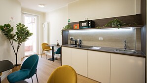 A modern kitchen with a built-in stove, sink, and a small dining area with chairs. - Romantic Suite with jacuzzi near Vatican (Room 2) (Roma)