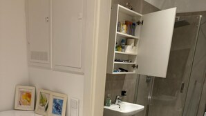 A modern bathroom with a white vanity, a glass shower enclosure, and a toilet. - Comfort 1BR Studio Near Matzleinsdorfer (Vienna)