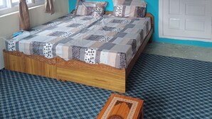A bedroom with a bed, curtains, a door, and a window. - Best place to spend your night in clean and cozy bedroom.
In The Himalaya (Nako)