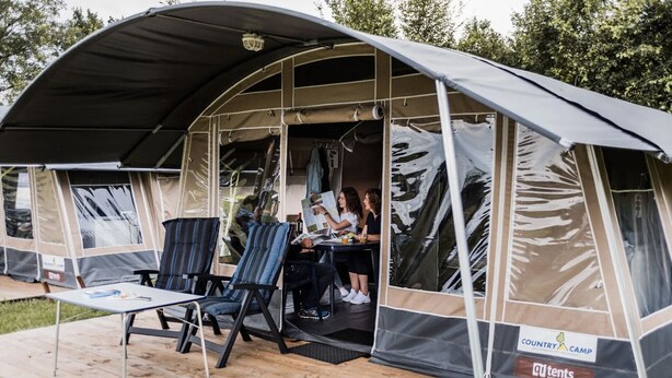 Ein Zelt mit überdachter Veranda, einem Tisch und zwei Stühlen.