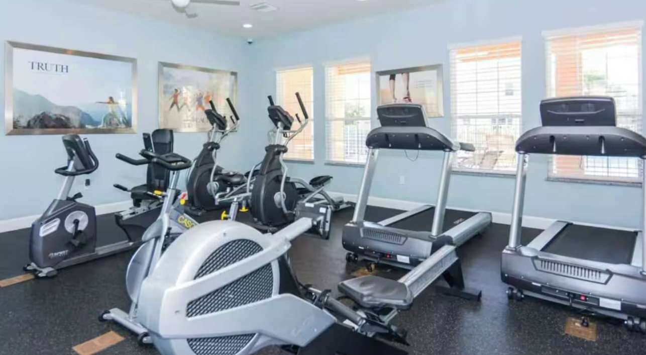 Una palestra con tapis roulant, ellittiche e cyclette.