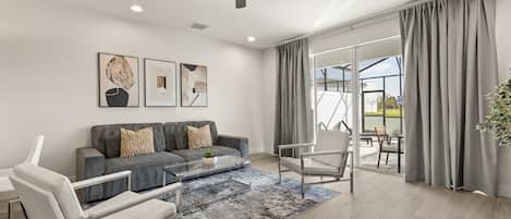 A modern living room with a sofa, chairs, a coffee table, and artwork on the wall.
