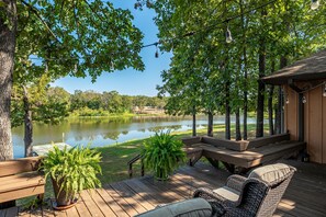 A wooden deck with a bench, a wicker chair, and a potted plant. - "Peace" of Heaven. Private lake. Fish dock.4Bd2.5Ba (Mead)