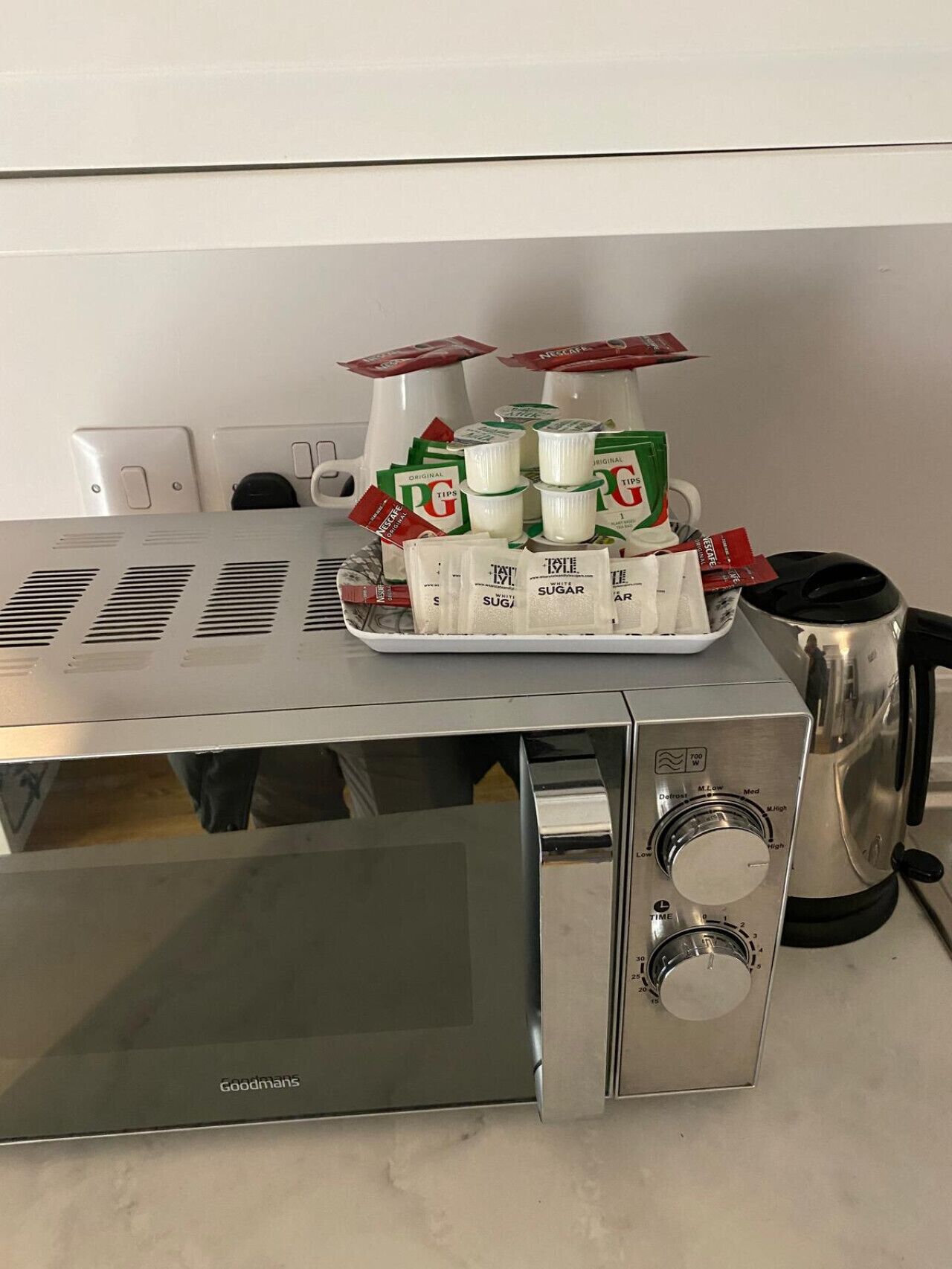 A kitchen with a stainless steel microwave and a coffee maker.