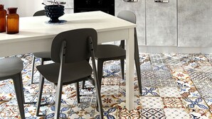 Una cocina moderna con encimera blanca, armarios grises y azulejos decorativos en la pared.