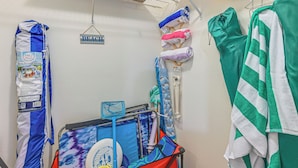A room with a bed, a small table with a tray, and a hanging rack with towels and a bag. - Stroll to Bonita Beach Park: Ocean-view Getaway (Bonita Springs)