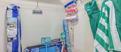 Une chambre avec un lit, une petite table sur laquelle se trouve un plateau, et un porte-serviettes mural avec des serviettes et un sac.