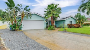 A residential house with a light blue exterior, a concrete driveway, and a well-maintained lawn. - Private Hot Tub, Pool & Yard: Modern Bradenton Gem (Bradenton)