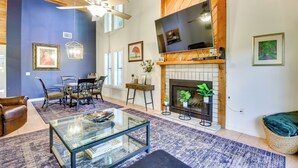 A spacious living room with a fireplace, a television, and a dining area with chairs and a table. - 5 Mi to Anna Maria Island: Apt w/ Pool Access! (Bradenton)