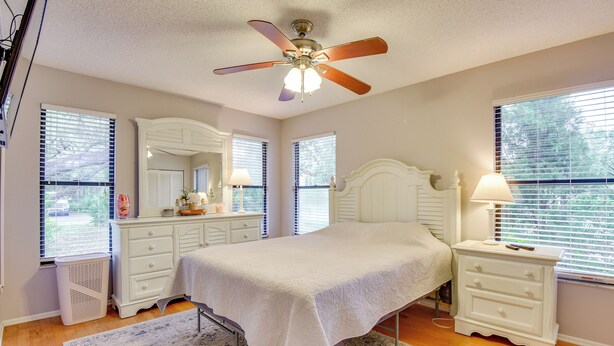 A bedroom with a bed, a nightstand, a dresser, a ceiling fan, and a window with blinds. - 5 Mi to Anna Maria Island: Apt w/ Pool Access! (Bradenton)