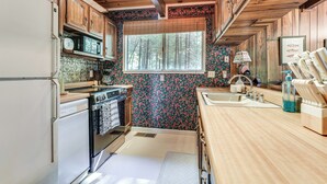 A compact kitchen with wooden cabinets, a refrigerator, a microwave, and a sink. - 4 Mi to State Park: Quiet Escape w/ Deck in Arnold (Arnold)
