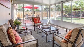 A sunroom with a glass door leading to a backyard patio area. - Suburban Home 9 Mi to Dtwn Denver: Outdoor Oasis! (Aurora)