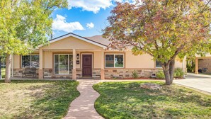 A single-story house with a front porch, a pathway leading to the entrance, and a well-maintained lawn. - Suburban Home 9 Mi to Dtwn Denver: Outdoor Oasis! (Aurora)