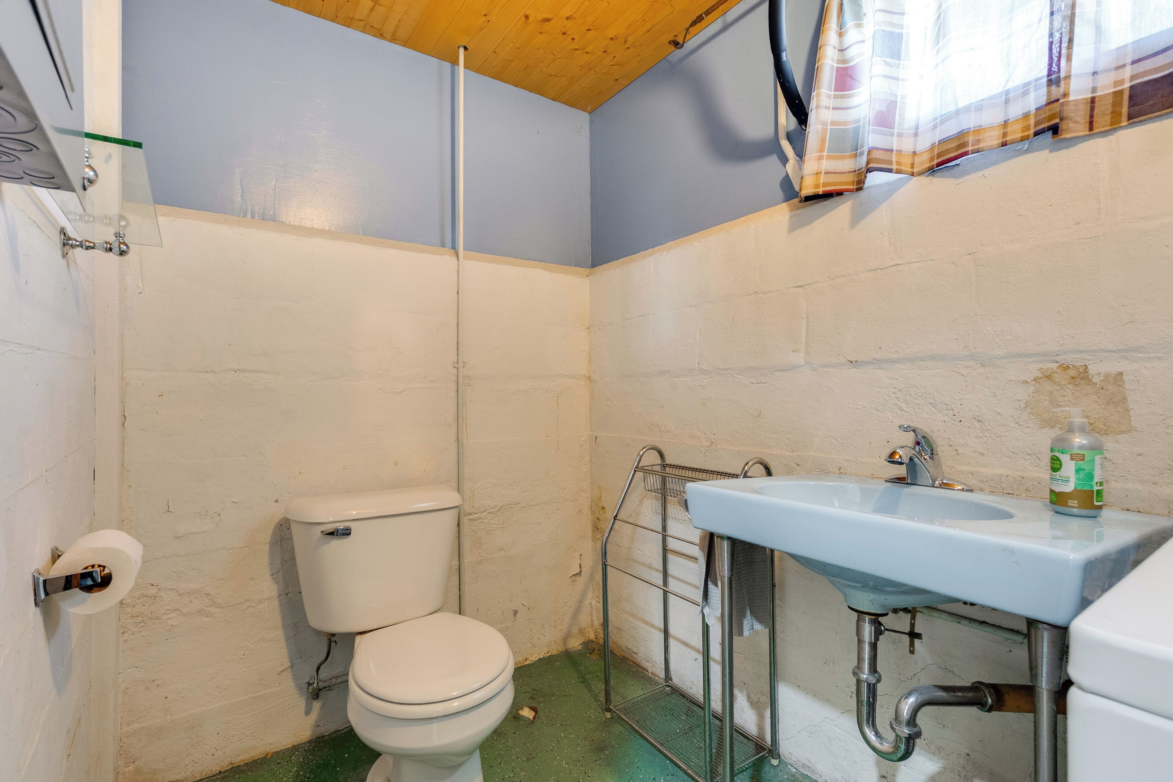 A small bathroom with a toilet, a sink, and a shower curtain.
