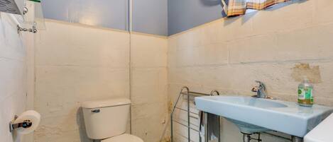 A small bathroom with a toilet, a sink, and a shower curtain.