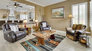 A spacious living room with leather sofas, a coffee table, and a large window with blinds. - Mtn-view Patio Oasis! Luxe Family Home in Peoria (Peoria)