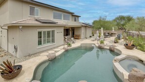 Una proprietà residenziale con piscina, mobili da patio e giardino curato.