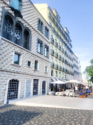 Ein historisches Gebäude mit einer einzigartigen, geometrischen Fassade, mehreren Balkonen und Außenbereichen mit Sitzmöglichkeiten.